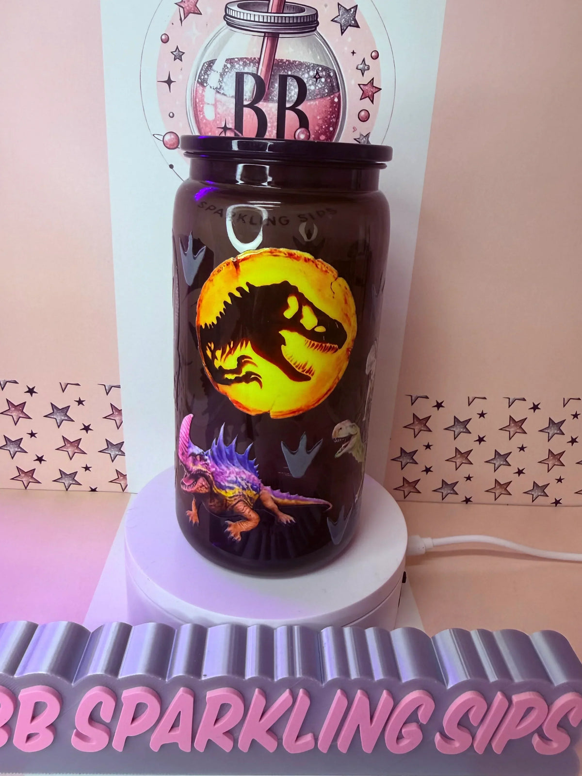 Dinosaur-themed glitter tumbler with T-Rex silhouette, glowing moon design, and colorful dinos on black cup
