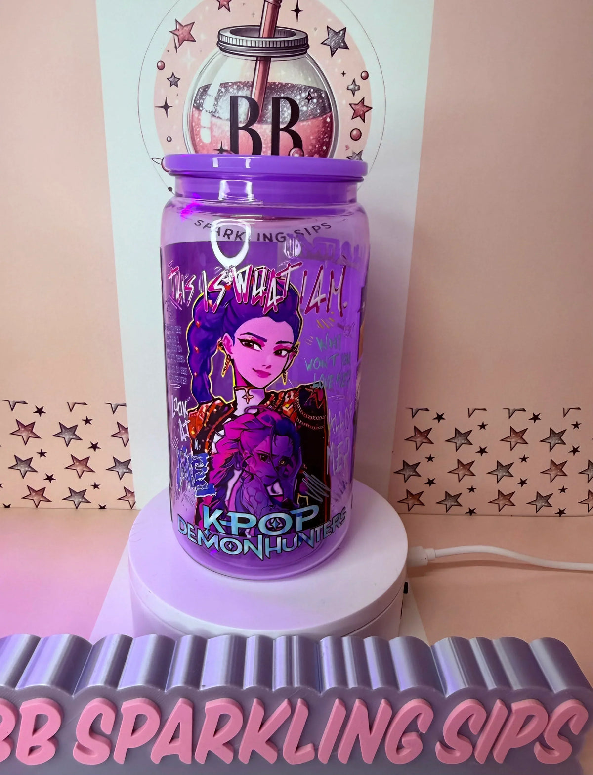 Purple K-Pop Demonhunters themed tumbler with glitter, UV DTF wrap, and 'This Is What I Am' design on display.