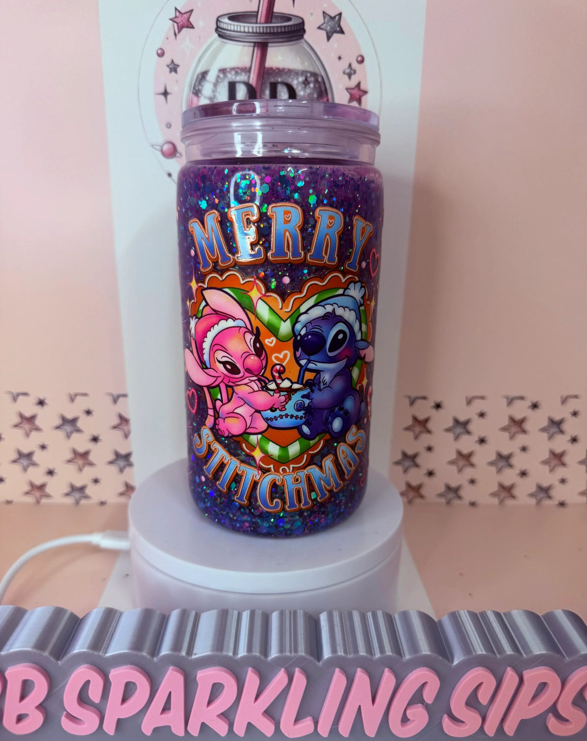 16oz acrylic glitter snowglobe cup with merry stitchmas design. Cold up. Reusable