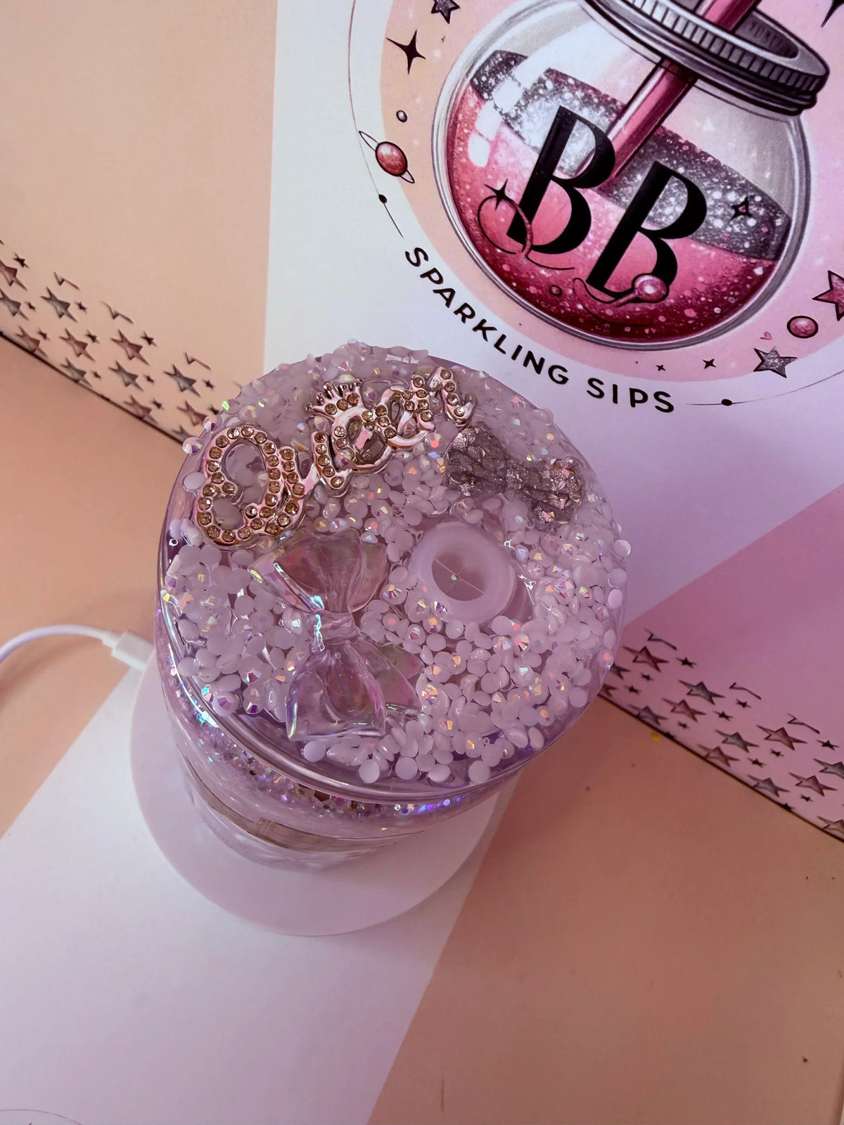 Pink glitter tumbler with rhinestone crown, bow, and beads, handmade custom cup