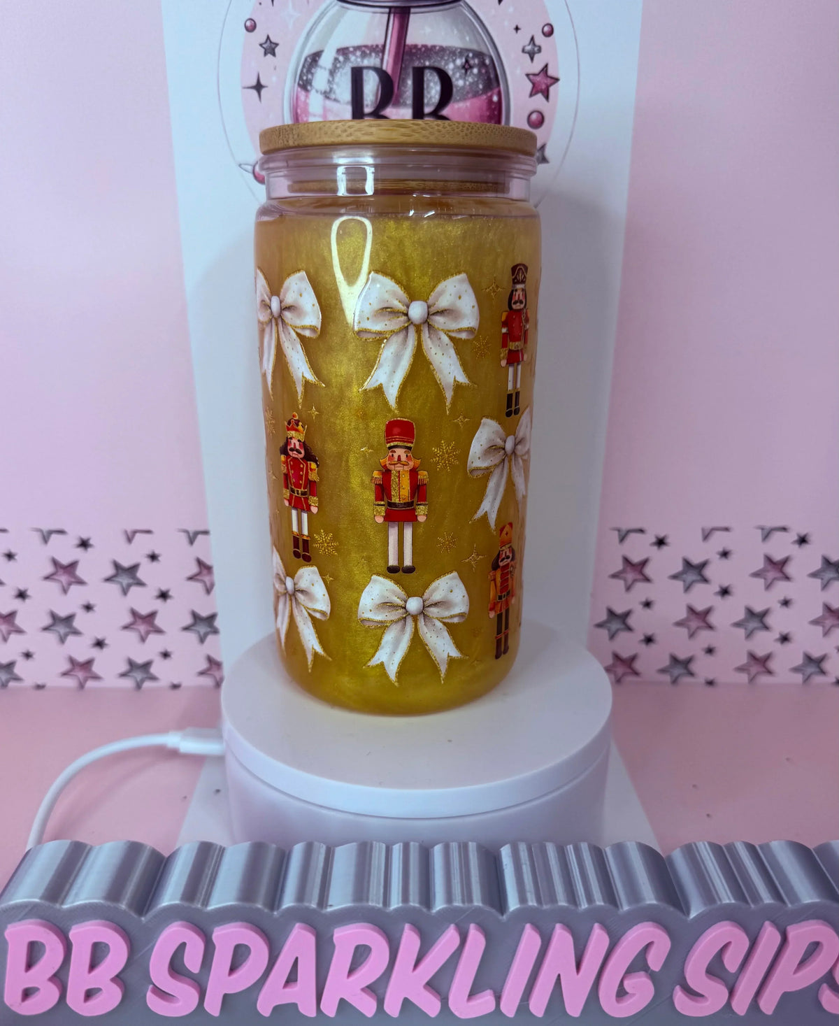 Golden glitter tumbler with nutcracker soldiers and white bows, handmade custom cup with bamboo lid